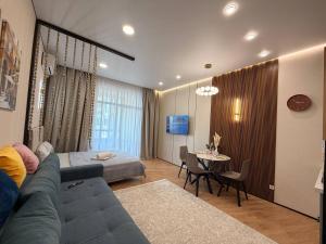 a living room with a blue couch and a table at ЖК Tandau 399 in Almaty
