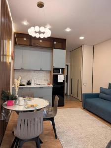 a kitchen and a living room with a table and a couch at ЖК Tandau 399 in Almaty