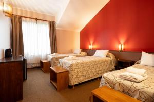 Ein Hotelzimmer mit zwei Betten und roten Wänden in der Unterkunft Pudu Lodge in El Chalten + 31 Fotos
