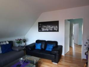 a living room with a black couch and blue pillows at Apartment Gill by Interhome in Stelle