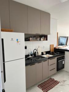 a kitchen with white cabinets and a white refrigerator at CASA MARECHAL FRANCÊs in Marechal Deodoro