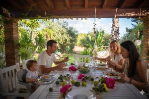 a family sitting around a table eating food at Dimora Virone Paradiso in Naro