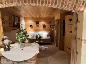 a room with a bed and a christmas tree on a table at LA VARNACHE logement cosy in Bonvillard +22 photos