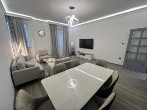 a living room with a table and a couch and a tv at Nasma Homes Al Dana in Abu Dhabi