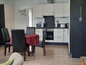 a kitchen with a table and chairs and a kitchen with white cabinets at Apartment Gill by Interhome in Stelle