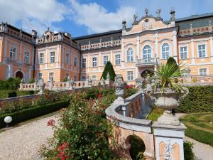 a large building with a garden in front of it at Apartmány Wake up Coffee in Proseč