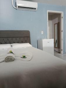 a bedroom with a large white bed with a fan at Hospedaria Temporarte in Piranhas