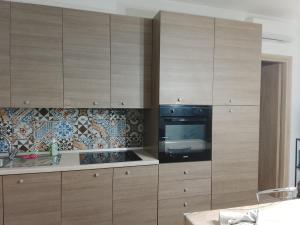 a kitchen with wooden cabinets and a black oven at Le stanze di veneranda in Silvi Marina