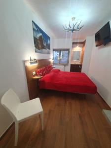 a bedroom with a red bed and a chair at Il RIFUGIO DELLO SCIATORE RESIDENCE PARADISO in Roccaraso