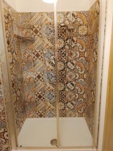 a shower with a tiled wall in a bathroom at Le stanze di veneranda in Silvi Marina +14 photos