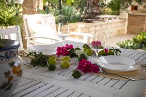 a table with plates and wine glasses and flowers at Dimora Virone Paradiso in Naro +87 photos