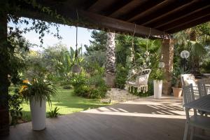 a patio with a chair and a garden with plants at Dimora Virone Paradiso in Naro