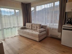 a living room with a couch in front of windows at Villa Nikol Apartment #4 in Raduil