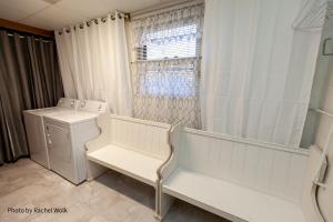 a white laundry room with a washer and a window at O'Brien's Sanctuary in Candler