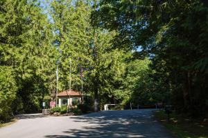 a tree lined road with a house in the middle at Tall Chief Camping Resort Yurt 5 in Pleasant Hill