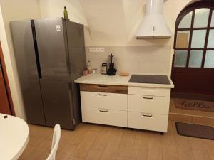 a kitchen with a stainless steel refrigerator and white cabinets at Cassovia Hostel in Košice