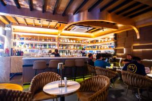 a restaurant with people sitting at tables and a bar at ไดมอนด์ โฮเทล in Ban Krasang