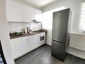 a kitchen with white cabinets and a black refrigerator at Apartment Studio-Wohnung Heide2 mit Terrasse by Interhome in Walsrode