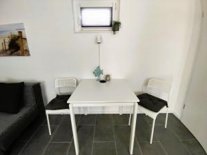 a white table and two chairs in a living room at Apartment Studio-Wohnung Heide2 mit Terrasse by Interhome in Walsrode