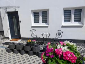 a patio with chairs and flowers in front of a house at Apartment Studio-Wohnung Heide2 mit Terrasse by Interhome in Walsrode
