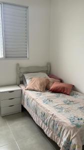 a bed with two pillows on it in a bedroom at Doce lar in Pouso Alegre