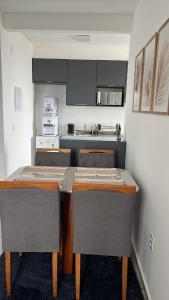 a kitchen with a table and chairs in a room at Doce lar in Pouso Alegre