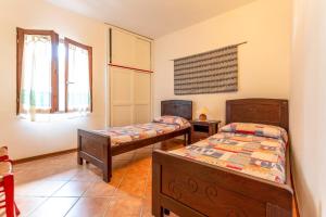 a bedroom with two beds and two windows at Asfodeli Holiday Home in Monte Nai