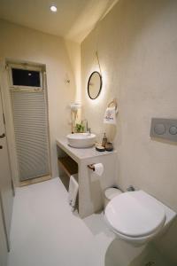 a bathroom with a white toilet and a sink at Alba Terra Houses in Pamukkale +15 photos