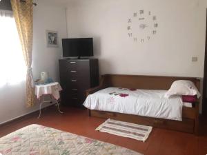 a bedroom with a bed with a clock on the wall at The Lemon Tree House in Quinta do Conde