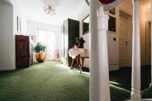 a room with green carpet and a table in a room at Hotel Oasi in Cortina dʼAmpezzo
