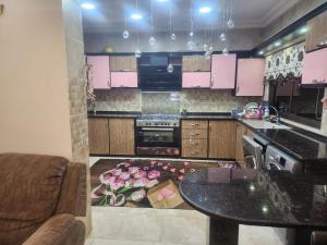 a kitchen with pink cabinets and a table and a rug at A big Family nice sunset flat in Amman