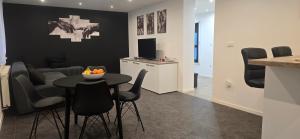 a dining room and living room with a table and chairs at Apartman Tango in Zaprešić