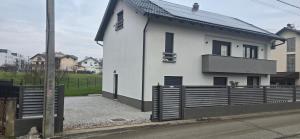 a white house with a wooden fence in front of it at Apartman Tango in Zaprešić