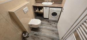 a bathroom with a toilet and a sink and a washing machine at Apartman Tango in Zaprešić +13 photos