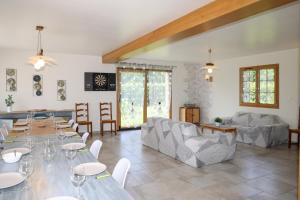 a living room with a table and chairs and a room with at Gîte À la Bonne Compagnie in Preures