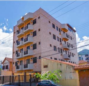 a tall brick building with windows on the side of it at Apartamento Centro Ubatuba - Ubatuba House Temporada in Ubatuba