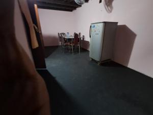 an empty room with a table and a refrigerator at A-Kutty in Irinjālakuda