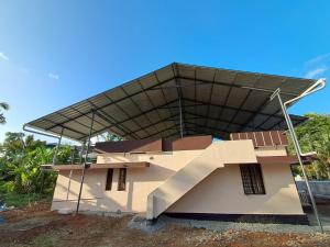 a building with a roof with a staircase at A-Kutty in Irinjālakuda