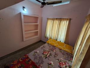 a small room with a bed and a window at A-Kutty in Irinjālakuda