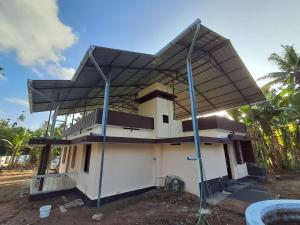 a house with a metal roof on top of it at A-Kutty in Irinjālakuda