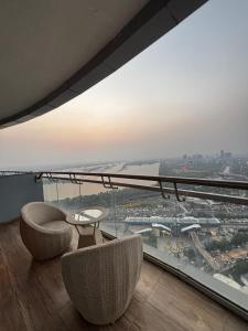 a room with two chairs and a table and a large window at Supernova spira in Noida