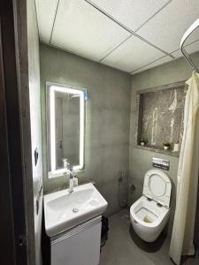 a bathroom with a white toilet and a sink at Supernova spira in Noida +9 photos