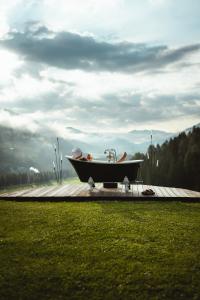 a bath tub sitting on top of a wooden deck at Gailerhof Boutique Hotel B&B Dolomites in Monguelfo