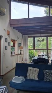a blue couch in a living room with a large window at Casa con pileta, Mar Azul in Mar Azul