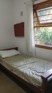 a bed in a room with a window and a bed sidx sidx sidx at Casa con pileta, Mar Azul in Mar Azul +29 photos