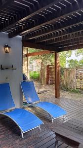 two blue lawn chairs sitting on a deck at Casa con pileta, Mar Azul in Mar Azul