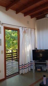 a living room with a sliding glass door to a deck at Casa con pileta, Mar Azul in Mar Azul