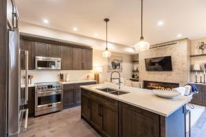 a kitchen with wooden cabinets and stainless steel appliances at Polar Peak Lodges by Fernie Central Reservations in Fernie