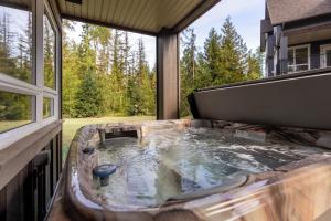 a hot tub on the back of a house at Polar Peak Lodges by Fernie Central Reservations in Fernie +100 photos