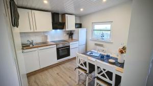 a kitchen with white cabinets and a table with chairs at Ferienwohnung Dennis in Nordleda
